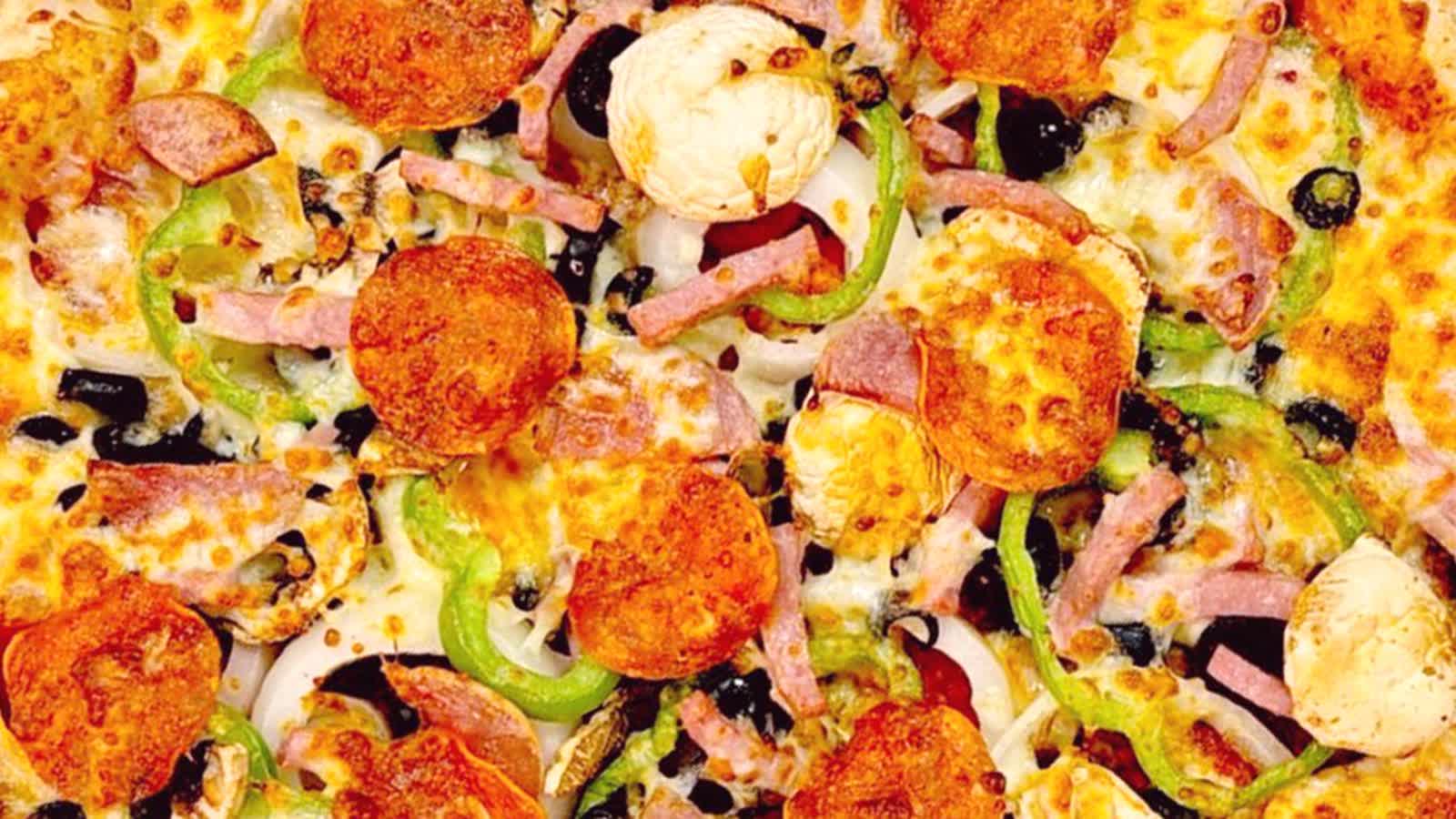 Pizza van Pizza Spot met pepperoni, ham, champignons, groene paprika, zwarte olijven en ui.